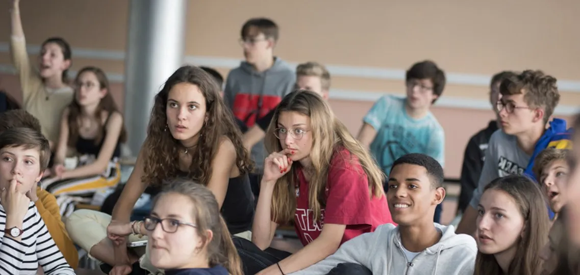 Des collégiens assis en groupe, attentifs, pendant un atelier
